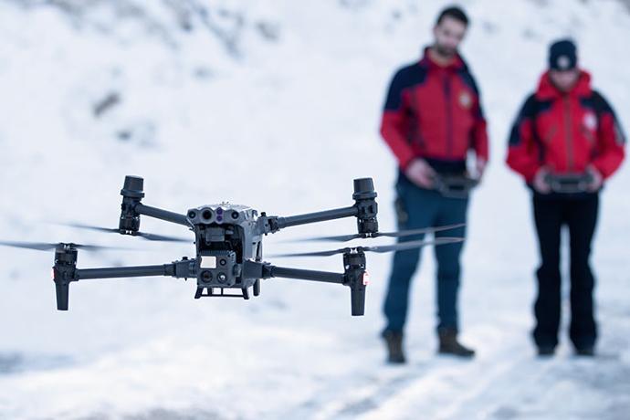 DJI M30T deployed on search and rescue mission with pilots in the background.
